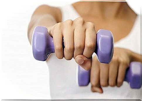 Woman exercising with dumbbells - gives firmer breasts