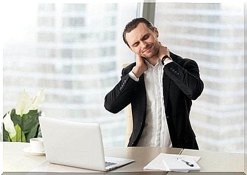 Man trying to relieve muscle cramps at computer