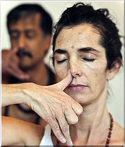 Woman and man blocking right nostrils - breathing techniques