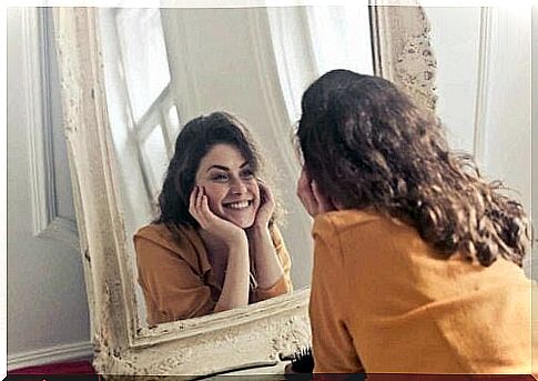 Woman smiles to herself in the mirror