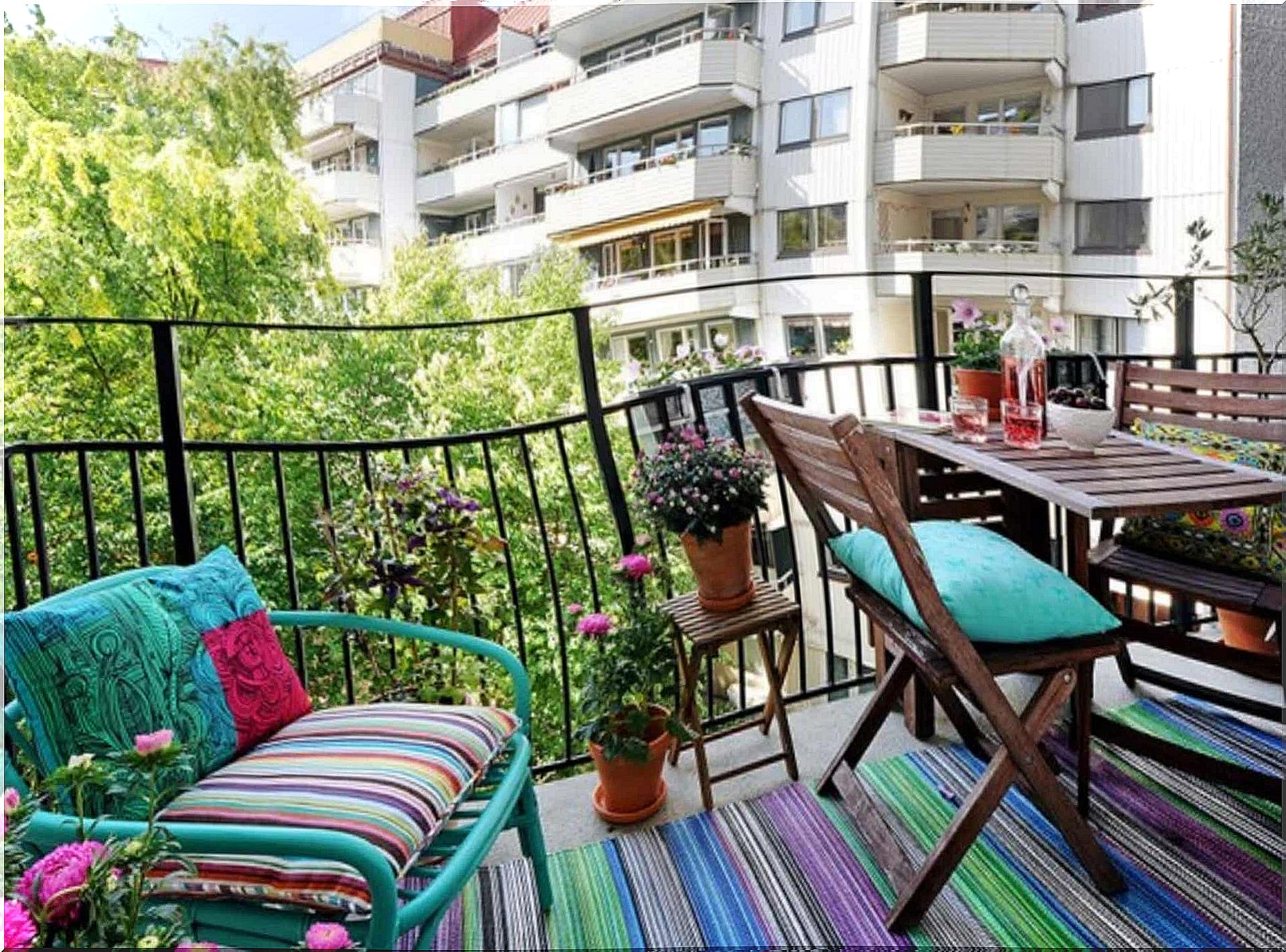 A balcony with table and chairs and a bench