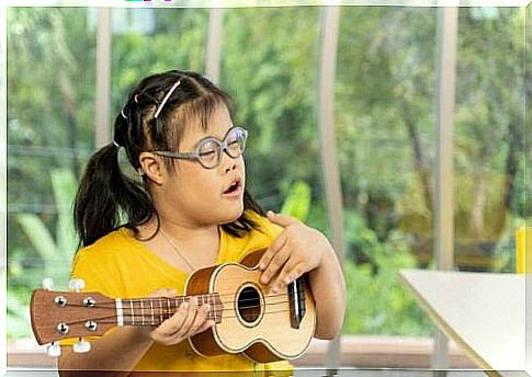 Girl with Down Syndrome plays guitar as an example of people with intellectual disabilities