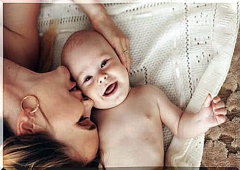 Mom kissing smiling baby