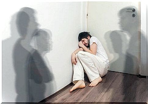 Scared man in corner experiencing schizophrenia