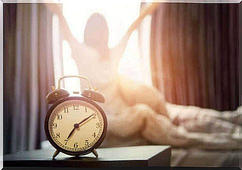 Alarm clock in front of woman ready to start the day with the SAVERS method