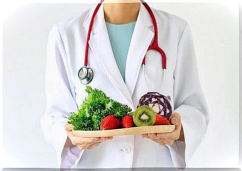 Doctor stands with healthy foods to illustrate the glycemic index