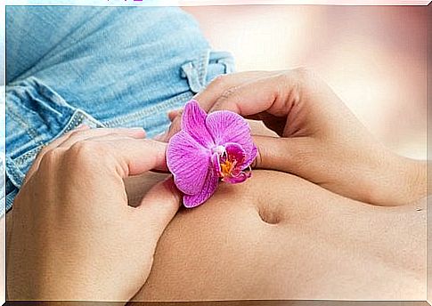 Woman holding a flower on her belly